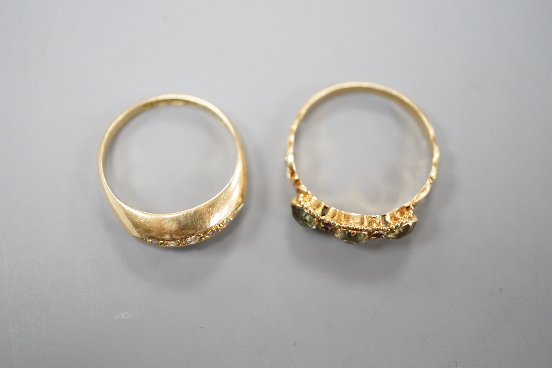 A George V 18ct gold and graduated five stone diamond chip set half hoop ring, size L/M, gross 2.4 grams and a Victorian yellow metal and gem set ring (stone missing), gross 1.8 grams.